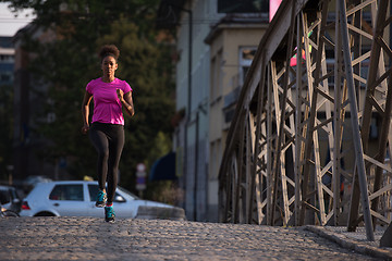 Image showing african american woman running across the bridge