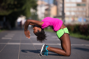 Image showing sporty young african american woman stretching outdoors