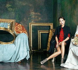 Image showing beauty rich brunette woman in luxury interior near empty frames, wearing fashion clothes, lifestyle people concept