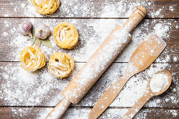 Image showing Wooden rolling pin with flour and pasta