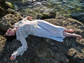 Image showing Young Lady Ethic Dress Lying on Sea Rock