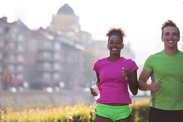 Image showing young multiethnic couple jogging in the city