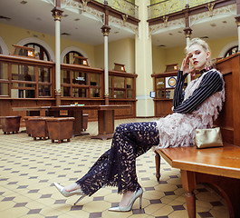 Image showing young attractive fashion lady on railway station waiting, vintage people concept in classic interior