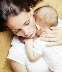 Image showing young brunette happy mother holding toddler baby son, breast-feeding concept, lifestyle modern people