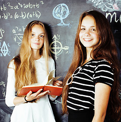 Image showing back to school after summer vacations, two teen real girls in classroom with blackboard painted together, lifestyle real people concept