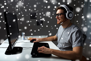 Image showing man in headset playing computer video game at home