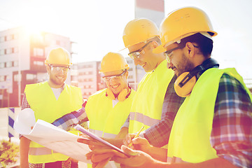 Image showing group of builders with tablet pc and blueprint