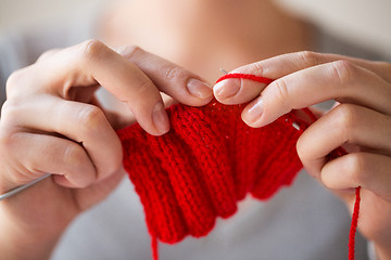 Image showing close up of hands knitting with needles and yarn