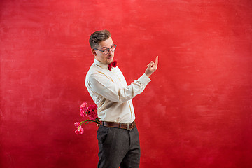 Image showing Man holding bouquet of carnations behind back