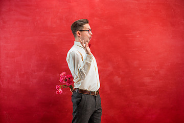 Image showing Man holding bouquet of carnations behind back