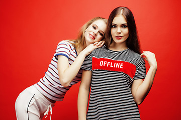 Image showing two best friends teenage girls together having fun, posing emotional on red background, besties happy smiling, lifestyle people concept