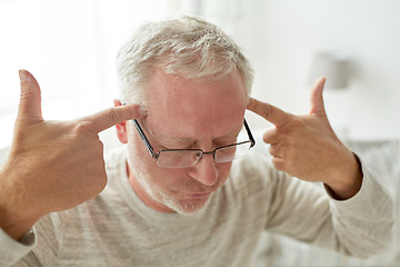 Image showing senior man suffering from headache at home