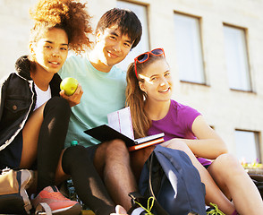 Image showing cute group of teenages at the building of university with books huggings, diversity nations