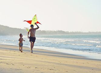 Image showing father with son, sunset at the seacoast playing kite, happy family 