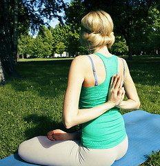 Image showing blonde real girl doing yoga in green park on grass