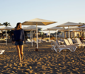 Image showing real blrunette girl along on seacost walking, healthy at sunrise, hotel resort 