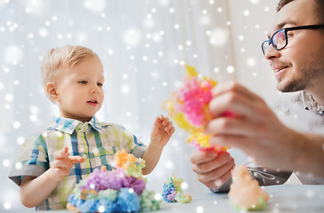 Image showing father and son playing with ball clay at home