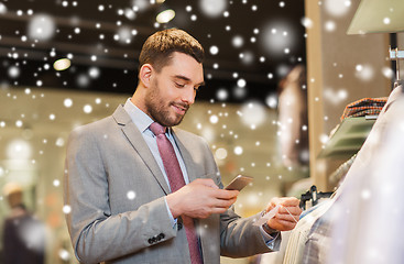 Image showing man in suit with smartphone at clothing store