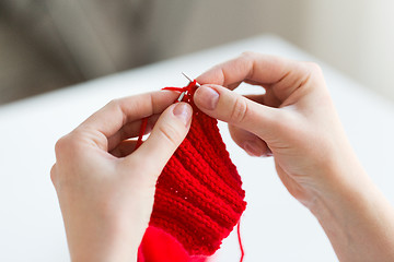 Image showing close up of hands knitting with needles and yarn