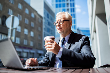 Image showing senior businessman with laptop drinking coffee