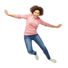 Image showing happy african american woman jumping over white