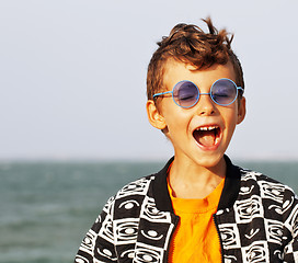 Image showing cute little boy at seacoast in fashion clothers and blue glasses