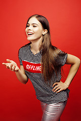 Image showing young pretty emitonal posing teenage girl on bright red background, happy smiling lifestyle people concept