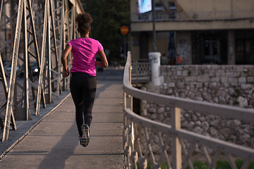 Image showing african american woman running across the bridge