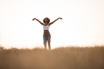 Image showing young black girl dances outdoors in a meadow