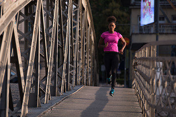 Image showing african american woman running across the bridge