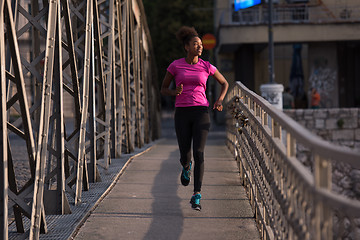 Image showing african american woman running across the bridge