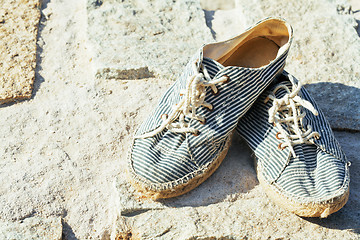 Image showing picture of vintage old shabby sneakers at seacost, real forgotte