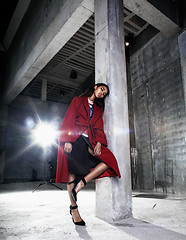 Image showing young beauty african american woman in red coat  strange build