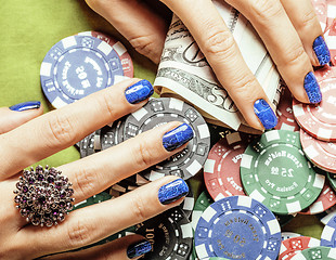 Image showing hands of young caucasian woman with red manicure at casino table