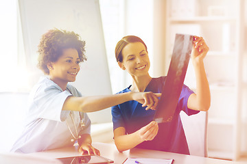 Image showing happy female doctors with x-ray image at hospital