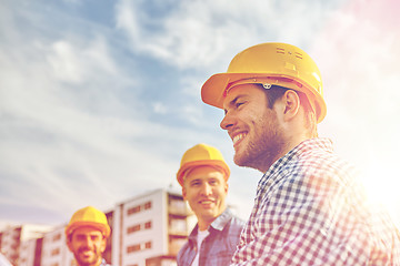 Image showing group of smiling builders in hardhats outdoors