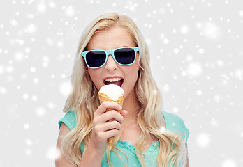 Image showing happy young woman in sunglasses eating ice cream