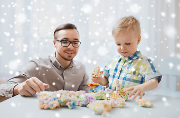 Image showing father and son playing with ball clay at home