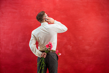 Image showing Man holding bouquet of carnations behind back