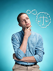 Image showing The serious young man over blue background