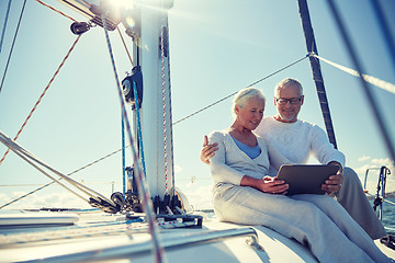 Image showing senior couple with tablet pc on sail boat or yacht