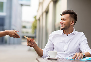 Image showing man with euro money paying for coffee at cafe