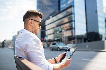 Image showing man with tablet pc sitting on city street bench