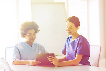 Image showing happy doctors with tablet pc meeting at hospital