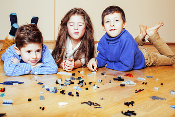 Image showing funny cute children playing lego at home, boys and girl smiling, first education role lifestyle