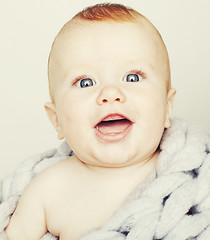 Image showing little cute red head baby in scarf all over him close up isolate