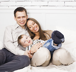 Image showing young happy modern family smiling together at home. lifestyle people concept, father holding baby son