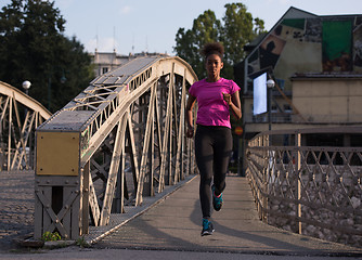 Image showing african american woman running across the bridge