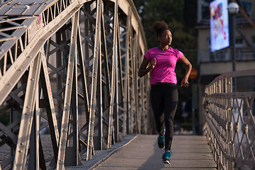 Image showing african american woman running across the bridge