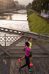 Image showing young multiethnic couple jogging in the city